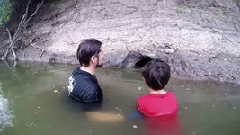 Father Teaches Son How to Catch Fish by Hand.