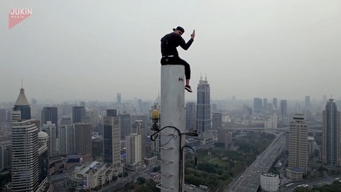 Guy Climbs to Tip of Building