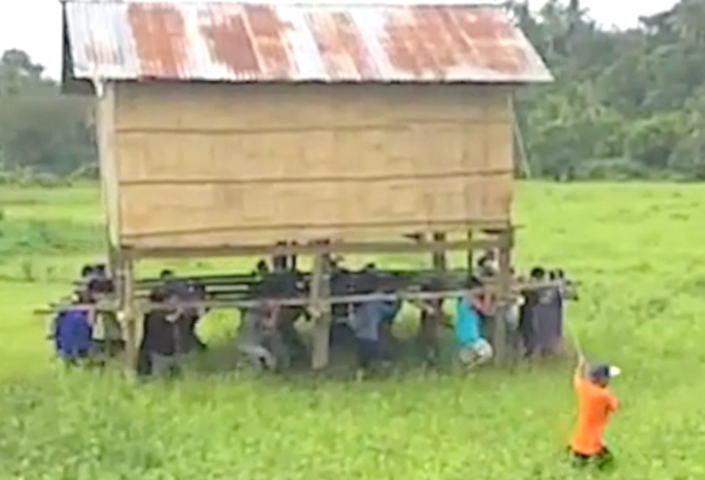 Community effort! Filipino villagers help neighbour carry house to new location