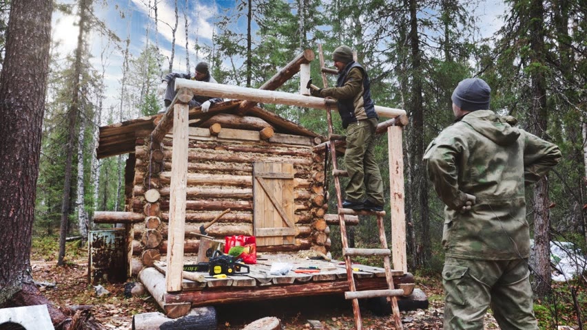 Harsh men building a log cabin. Food on the campfire. Life in a log cabin.