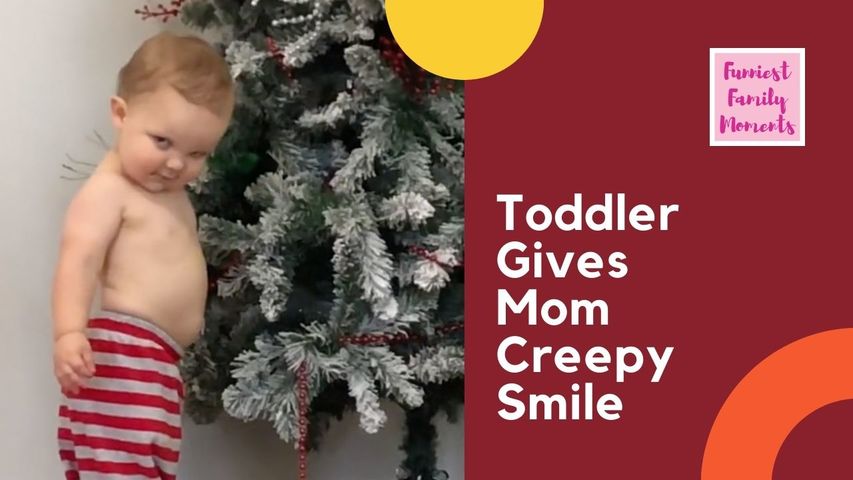 Toddler Staring at Christmas Tree Gives Creepy Smile When Mom Calls Him